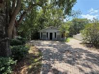 Charming home featuring a paved driveway and a cozy, inviting entrance surrounded by mature trees at 1523 S Mellonville Ave, Sanford, FL 32771