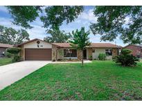 Charming one-story home featuring a well-maintained lawn, a two-car garage, and beautiful stone accents at 1830 W Clinton Dr, St Cloud, FL 34769