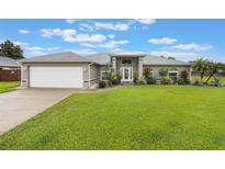 Charming single-story home with a well-manicured lawn and neutral exterior at 2113 Kirkland Lake Dr, Auburndale, FL 33823