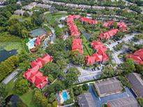 An aerial view of a condo complex with red roofs, green trees, and a pool with tennis courts at 238 Afton Sq # 204, Altamonte Springs, FL 32714