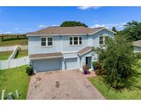 Charming two-story home with a two car garage, beautiful brick driveway and manicured landscaping at 816 Carmillion Ct, Groveland, FL 34736