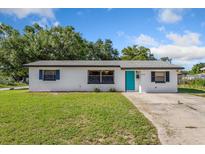 Charming one-story home with a well-maintained lawn and a bright teal front door at 911 Ursula St, Ocoee, FL 34761