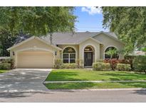 Charming single-story home with manicured lawn, arched windows, and attached two-car garage at 10146 Pointview Ct, Orlando, FL 32836