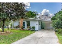 Charming single-story home featuring a well-manicured front yard and a convenient covered carport at 11 S University Cir, Deland, FL 32724