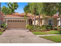 Charming single-story home featuring a tile roof, brick driveway, and lush landscaping at 11316 Rapallo Ln, Windermere, FL 34786