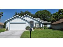 Charming single-story home features a well-manicured lawn and attached two-car garage at 11818 Sophia Ln, Orlando, FL 32821