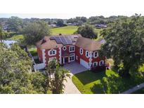 Stunning two-story home with a red exterior, white trim, and a solar panel roof system at 1254 Shelter Rock Rd, Orlando, FL 32835