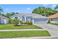 Charming single-Gathering home with a well-maintained lawn, gray paint, and a two-car garage at 12618 Lakebrook Dr, Orlando, FL 32828