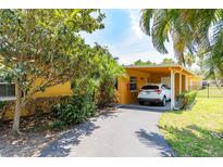 Charming carport of home featuring lush landscaping, driveway and a parked car at 2272 Raeford Rd # A-3, Orlando, FL 32806