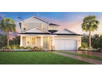 Inviting two-story home featuring a well-manicured lawn, attached two-car garage, and craftsman-style accents at 2659 Fiddle Leaf Loop, Apopka, FL 32712