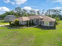 Stunning single-story home with lush landscaping, verdant lawn, and a separate barn on a sprawling lot at 2659 Hibbard Trl, Chuluota, FL 32766