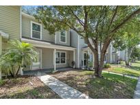 Charming two-story home with a sidewalk leading to the front door and a mature tree providing shade at 283 Woodgreen Ln, Winter Springs, FL 32708