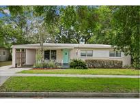 Charming single-story home featuring a light pink exterior, quaint front yard and a light teal colored front door at 3007 Huntington St, Orlando, FL 32803
