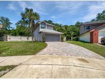 Charming home with a well-manicured lawn, brick driveway, and tropical landscaping at 306 Foxboro Ct, Lake Mary, FL 32746