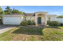 Charming single-story home with a two-car garage, manicured landscaping, and welcoming front porch at 3270 Courtland Blvd, Deltona, FL 32738