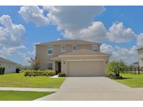 Charming two-story home featuring a spacious two-car garage, lush lawn, and beautiful landscaping at 356 Quarry Rock Cir, Kissimmee, FL 34758