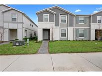 Charming two-story townhome with gray siding, well-maintained lawn, and inviting entrance at 4314 Lana Ave, Davenport, FL 33897