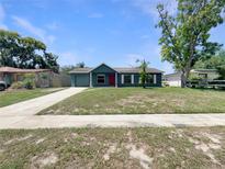 Charming one-story home with a well-maintained lawn, garage, and red front door at 472 Little Aspen Ct, Ocoee, FL 34761