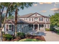 Elegant two-story home with a well-manicured lawn and charming curb appeal with its symmetrical windows and neutral paint scheme at 7536 Green Mountain Way, Winter Garden, FL 34787