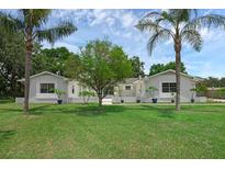 Charming home featuring a well-manicured lawn and palm trees, offering a welcoming curb appeal at 103 Longhorn Rd, Winter Park, FL 32792