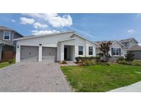 Charming single-story home with a two-car garage, manicured lawn, and modern architectural style at 14741 Milfoil Ave, Orlando, FL 32827