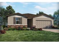 Charming single-story home featuring stone accents, a two-car garage, and a beautifully landscaped front yard at 1737 Forest Run Ln, Auburndale, FL 33823