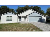 Charming single-Gathering home with a well-manicured front yard, brick driveway, and an attached two-car garage at 2009 Nottingdale Ln, Winter Park, FL 32792