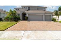 Stunning two-story home boasts a brick driveway and lush landscaping at 2061 Rush Bay Way, Orlando, FL 32824