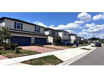 Charming row of two-story homes featuring brick driveways and a well-maintained street view at 2450 Sweet Viburnum Way, Ocoee, FL 34761