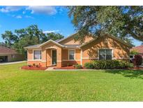 Charming single-story home featuring well-manicured lawn, mulch beds, and a welcoming front entrance at 2619 Breezy Meadow Rd, Apopka, FL 32712