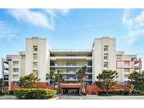 Beautiful condominium complex with lush landscaping, covered parking, and blue balcony railings at 5300 S Atlantic Ave # 6-507, New Smyrna Beach, FL 32169