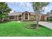 Charming brick home featuring a well-manicured lawn and mature landscaping, creating excellent curb appeal at 633 N Longview Pl, Longwood, FL 32779