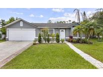 Charming single-story home featuring a well-maintained lawn, landscaped garden, and a two-car garage at 896 Satin Leaf Cir, Ocoee, FL 34761