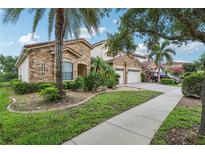 Beautiful two-story home with stone facade, red tile roof, tropical landscaping, and a two-car garage at 9736 Hatton Cir, Orlando, FL 32832