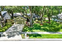 Charming home features lush lawn, mature trees, tidy landscaping, and a two-car garage at 1608 Victoria Way, Winter Garden, FL 34787