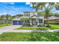 Charming two-story home featuring a beautifully landscaped yard and a welcoming front porch at 10252 Kristen Park Dr, Orlando, FL 32832