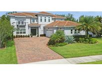 Beautiful two-story home featuring a brick driveway, lush landscaping, and a neutral color scheme at 108 Stanton Estates Cir, Winter Garden, FL 34787