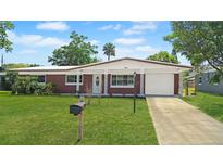 Charming brick home with a well-manicured lawn, inviting curb appeal, and attached one-car garage at 1119 Edith Dr, Daytona Beach, FL 32117