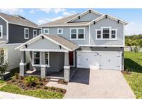 Beautiful two-story home featuring a 2-car garage, manicured lawn, and inviting covered front porch entry at 13081 Sunrise Harvest Dr, Winter Garden, FL 34787
