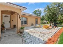 Inviting home entrance with a decorative water feature and well-maintained landscaping in the front yard at 1395 Deland Ave, Orange City, FL 32763