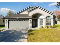 Charming single-story home featuring a grey two-car garage and well-manicured lawn at 149 Southampton Dr, Kissimmee, FL 34744