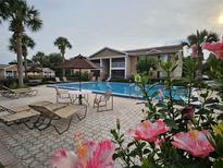 A serene pool surrounded by lush landscaping and comfortable lounge seating at 155 N Pearl Lake Cswy # 104, Altamonte Springs, FL 32714