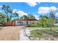 Charming single-story home with a gravel driveway and covered carport, showcasing its inviting curb appeal at 1705 Virginia Dr, Orlando, FL 32803