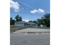 Single story home with gray siding, light colored roof, white railing, and a partial view of the front yard at 2233 N Normandy Blvd, Deltona, FL 32725