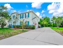 Charming two-story home featuring teal shutters, a well-manicured lawn, and an expansive driveway at 309 Black Springs Ln, Winter Garden, FL 34787