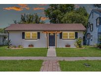Charming single-story home featuring a manicured lawn and a welcoming entrance with decorative pergola at 612 Florida Ave, St Cloud, FL 34769