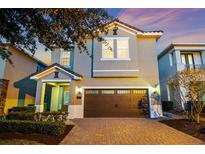 Charming two-story home featuring a brick driveway, two-car garage, and manicured landscaping at 640 Lasso Dr, Kissimmee, FL 34747