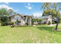 Charming home featuring manicured landscaping, a lush lawn, and brick accents at 802 Kaywood Dr, Orlando, FL 32825
