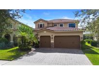 Beautiful two-story home boasts a tile roof, a paver driveway and a spacious three-car garage at 8312 Prestbury Dr, Orlando, FL 32832
