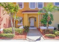 Charming yellow two-story home with well-maintained landscaping and a welcoming front entrance at 944 Park Terrace Cir, Kissimmee, FL 34746